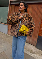 Leopard reverse over wide leg jeans with a bright yellow clutch