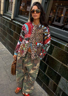Looking to camera in aviators with leopard collar peeking through the patchwork