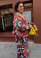 Smiling in patchwork styled with matching print trousers and a yellow clutch