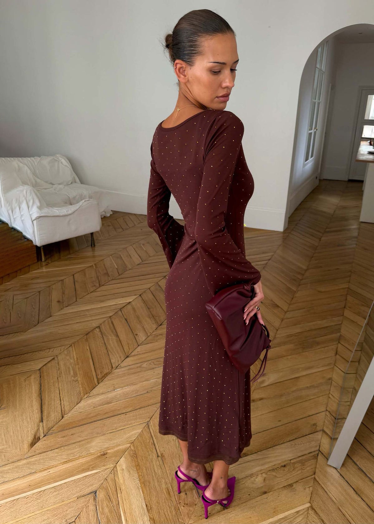 Never Fully Dressed Back view of the chocolate brown maxi dress with flared cuffs and fuchsia heels