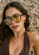 On-neck styling shot showing the charm cluster at the collarbone
