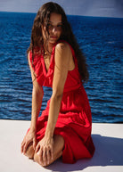Seated against an ocean backdrop, full skirt pooled at the floor